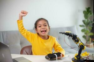 STEM education concept. Asian students learn at home by coding robot arms in STEM, mathematics engineering science technology computer code in robotics for kids' concepts. photo