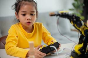 STEM education concept. Asian students learn at home by coding robot arms in STEM, mathematics engineering science technology computer code in robotics for kids' concepts. photo