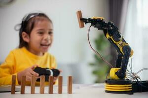 STEM education concept. Asian students learn at home by coding robot arms in STEM, mathematics engineering science technology computer code in robotics for kids' concepts. photo