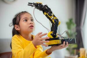 STEM education concept. Asian students learn at home by coding robot arms in STEM, mathematics engineering science technology computer code in robotics for kids' concepts. photo