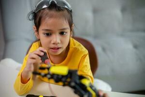 STEM education concept. Asian students learn at home by coding robot arms in STEM, mathematics engineering science technology computer code in robotics for kids' concepts. photo