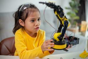 STEM education concept. Asian students learn at home by coding robot arms in STEM, mathematics engineering science technology computer code in robotics for kids' concepts. photo