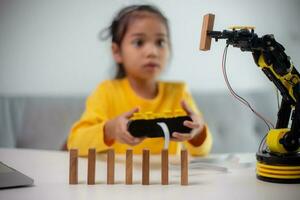 STEM education concept. Asian students learn at home by coding robot arms in STEM, mathematics engineering science technology computer code in robotics for kids' concepts. photo