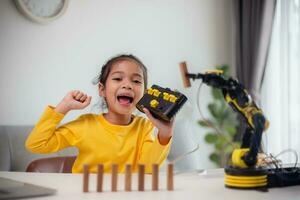 STEM education concept. Asian students learn at home by coding robot arms in STEM, mathematics engineering science technology computer code in robotics for kids' concepts. photo