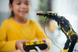 STEM education concept. Asian students learn at home by coding robot arms in STEM, mathematics engineering science technology computer code in robotics for kids' concepts. photo