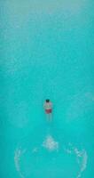 aéreo ver de un hombre en rojo pantalones cortos nadando en el piscina video