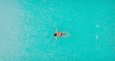 Aerial view of a man in red shorts swimming in the pool video