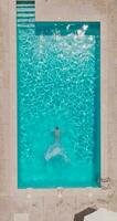 Aerial view of a man in red shorts swimming in the pool video