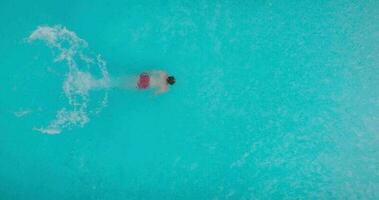 Antenne Aussicht von ein Mann im rot kurze Hose Schwimmen im das Schwimmbad video