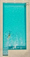 Antenne Aussicht von ein Frau im Gelb Badeanzug Schwimmen im das Schwimmbad. Sommer- Lebensstil video