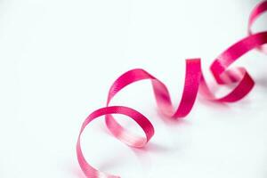 Pink ribbon for wrapping gifts on white background. photo