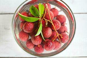 lychees on bowl with water for wash the fruit, fresh ripe lychee fruit tropical fruit lychees in Thailand - top view photo