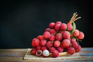 lychees on table and black background, fresh ripe lychee fruit tropical fruit peeled lychees slice in Thailand photo