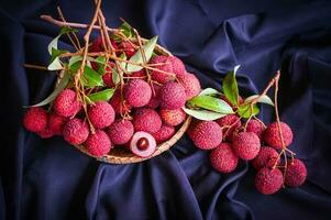 lychees on table and black background, fresh ripe lychee fruit tropical fruit peeled lychees slice in Thailand - top view photo
