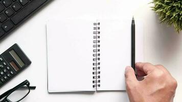 Top view of notepad and pen on white background video