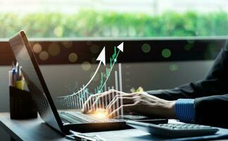 Businessman using laptop and analyzing economic growth, financial graph and business investment. planning strategy, stock market statistics, stock market trends, technical analysis strategy, value photo