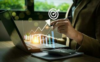 Business goals and marketing strategies. Businessman calculating business growth with arrow graph icon on laptop. economic, development, success, strategy, prospects, sustainable goals. photo