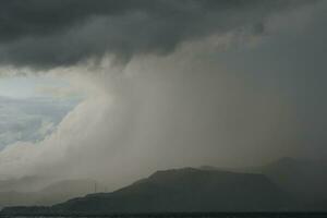 storm over the sea with mountains in the background photo