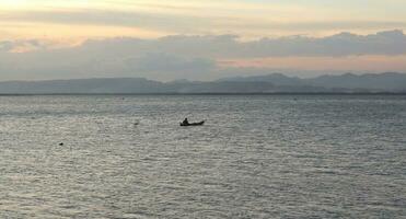 Fisherman Silhouette on His Boat photo