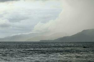 storm over the sea with mountains in the background photo