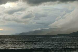 storm over the sea with mountains in the background photo