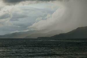 storm over the sea with mountains in the background photo