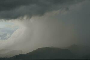 storm over the sea with mountains in the background photo