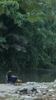 Gorontalo-Indonesia, May 2023 - Young man enjoying the morning atmosphere by the riverside photo