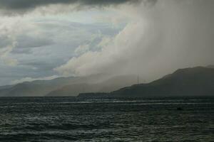 storm over the sea with mountains in the background photo