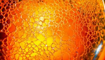 Golden honey drop on textured honeycomb, reflecting vibrant summer nature generated by AI photo