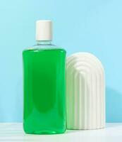 Refreshing mouthwash in a transparent plastic bottle  on a blue background photo