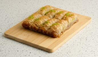 Pieces of baked baklava in honey and sprinkled with pistachios photo