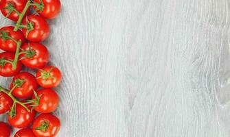 Top view, closup shot of delicious red tomatoes on gray wooden background with copy space photo