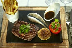 jugoso carne de vaca filete con papas fritas y tomate foto