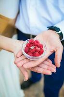 Wedding rings in a bowl with raspberries photo