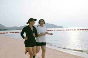 parejas asiático mujer corriendo en mar playa con felicidad foto