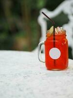 Red lemon soda water flavoured drink, Cool Drinks Beverages with ice in clear glass on white table photo