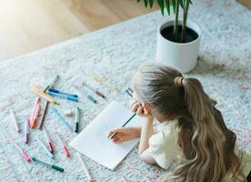 Child girl drawing with colorful pencils photo