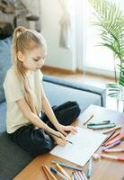 Child girl drawing with colorful pencils photo