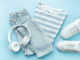 Child's t-shirt, shoes and headphones on blue backgrund photo