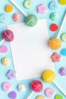 Sweet lollipops and candies and blank greeting card on blue background photo