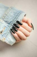 Hand of a young girl with black  manicure on nails photo