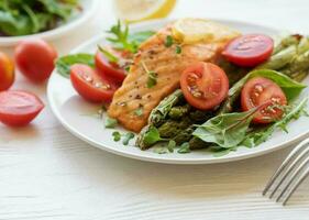 Baked Delicious salmon, green asparagus on  plate photo