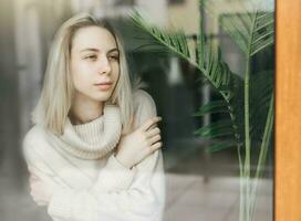 Sad girl near window thinking about something photo