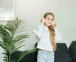 Cute little girl listening to music in headphones photo