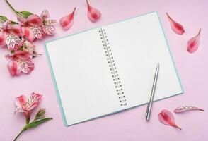 The notebook surrounded by pink Alstroemeria flowers and petals photo