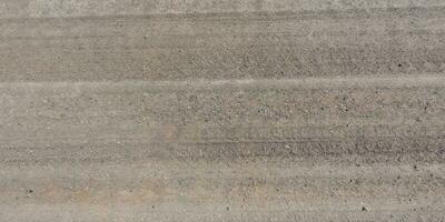 panorama of surface from above of gravel road with car tire tracks. photo