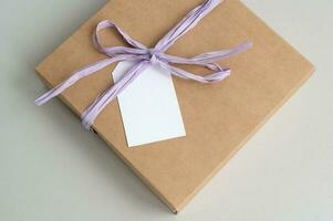 Boxes for parcels made of kraft paper on a gray background. Gift box with tag for text, logo photo
