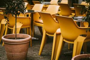 a street cafe with yellow plastic chairs photo