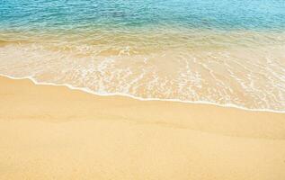 mar playa y azul Oceano con suave ola formar en arena textura, playa ver de marrón playa arena duna en soleado día verano, holizontal parte superior ver para verano bandera antecedentes. foto